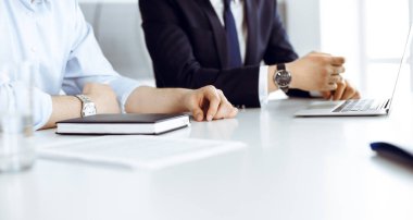 Bilinmeyen iş adamları modern ofisteki masada dizüstü bilgisayar kullanıyorlar. İş adamı ya da erkek girişimci meslektaşı ile birlikte çalışıyor. Takım çalışması ve ortaklık kavramı