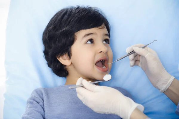 Cute árabe menino sentado na cadeira dentária com a boca aberta durante a verificação oral com o médico. Consulta ao dentista. Conceito de estomatologia — Fotografia de Stock