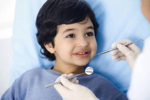 Cute árabe menino sentado na cadeira dentária com a boca aberta durante a verificação oral com o médico. Consulta ao dentista. Conceito de estomatologia — Fotografia de Stock