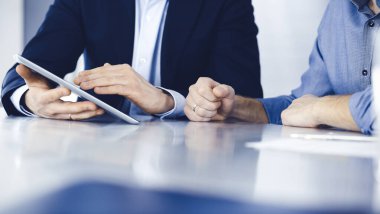 Modern ofiste birlikte çalışırken iş adamları tablet bilgisayar kullanıyorlar. İş yerinde iş arkadaşı olan tanınmamış bir iş adamı ya da erkek girişimci. Takım çalışması ve ortaklık kavramı