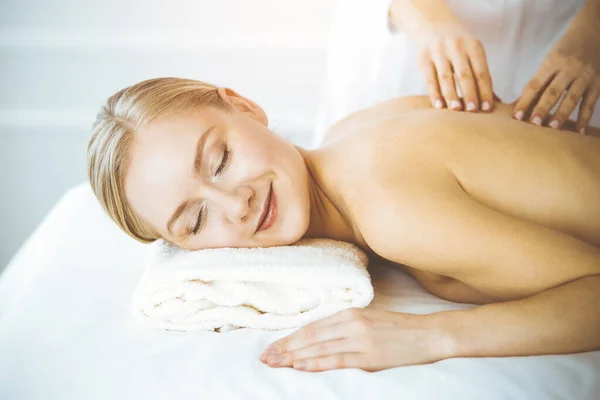 Szczęśliwa kobieta korzystająca z masażu pleców z zamkniętymi oczami. Koncepcja salonu piękności i spa — Zdjęcie stockowe