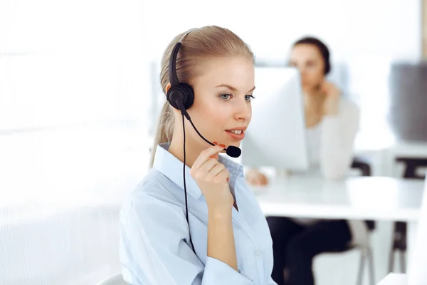 Operador de chamada mulher loira está usando computador e fone de ouvido para consultar clientes on-line. Grupo de pessoas diversas que trabalham como ocupação de atendimento ao cliente. Conceito de negócio — Fotografia de Stock