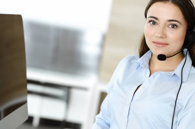 Esmer kadın müşteri hizmetleri temsilcisi internet üzerinden müşterilere danışıyor. Çağrı merkezi ve iş adamları kavramı