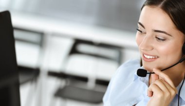 Esmer kadın müşteri hizmetleri temsilcisi internet üzerinden müşterilere danışıyor. Çağrı merkezi ve iş adamları kavramı