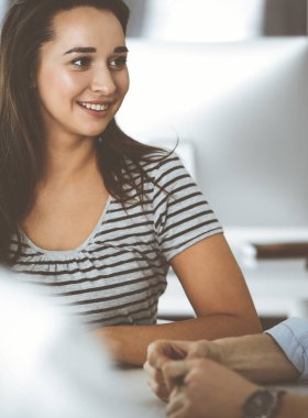 Bir grup iş adamı toplantıda soruları tartışıyor. Ofis görüşmelerinde iş arkadaşına gülümseyen sıradan giyinmiş iş kadınının vesikalığı. Şirket içinde takım çalışması ve işbirliği