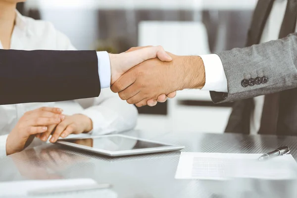 Handdruk als succesvol onderhandelingsresultaat, close-up. Onbekende zakenmensen schudden elkaar de hand na het tekenen van een contract in een modern kantoor — Stockfoto