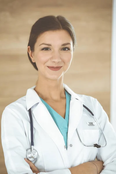 Doctora mujer de pie y mirando la cámara. Médico en el trabajo, retrato de estudio en el fondo médico. Concepto de medicina y salud — Foto de Stock