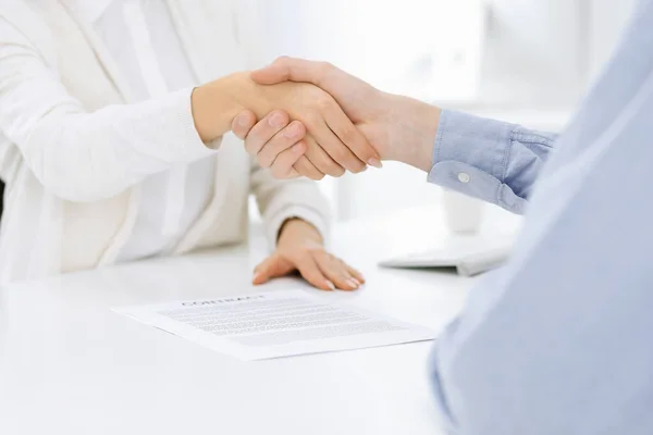Casual geklede zakenman en vrouw schudden handen na het contract ondertekenen in wit gekleurd kantoor. Handdruk concept — Stockfoto