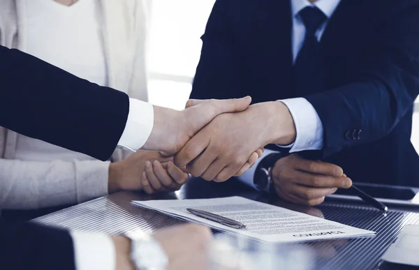 Zakenmensen schudden elkaar de hand na het tekenen van een contract in een modern kantoor. Teamwork, partnerschap en handdruk concept — Stockfoto