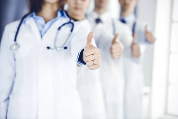 Grupo de médicos modernos em pé como uma equipe com polegares para cima no escritório do hospital. Ajuda médica, seguro em cuidados de saúde, melhor tratamento de doença e conceito de medicina — Fotografia de Stock