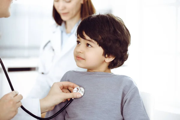 Docteur-femme examinant un enfant patient par stéthoscope. Joli garçon arabe sur rendez-vous chez le médecin. Concept de médecine — Photo