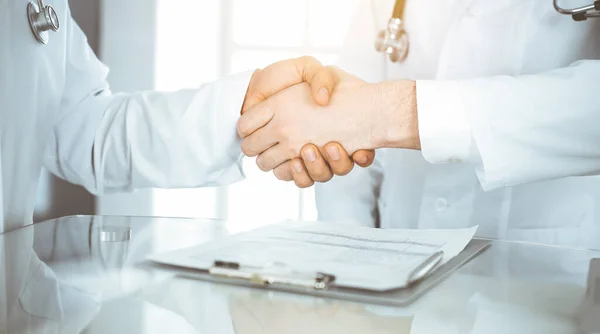 Due medici si stanno stringendo la mano come accordo sul trattamento dei pazienti, primo piano. Aiuto medico, concetto di medicina — Foto Stock