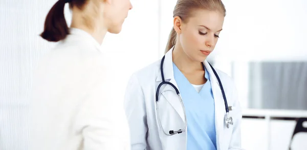 Mujer: el médico consulta a su paciente femenina mientras usa el portapapeles y el historial de medicamentos. Concepto de medicina — Foto de Stock