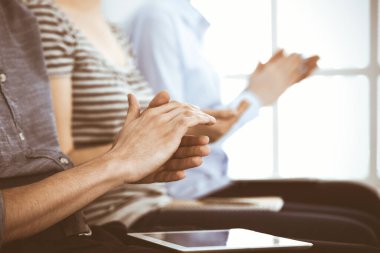 İş adamları toplantı ya da konferansta el çırpıyor. Modern beyaz ofisteki bir grup tanınmayan iş adamı ve kadın. Başarı takım çalışması, kurumsal koçluk ve alkış konsepti