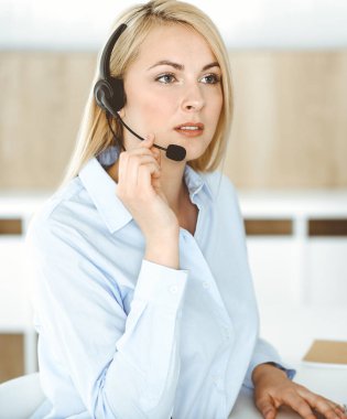 Sarışın bir iş kadını çağrı merkezinde kulaklıkla iletişim kuruyor. Teleskop işi kavramı