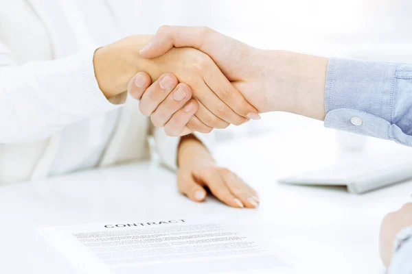 Casual hombre de negocios vestido y mujer estrechando las manos después de la firma del contrato en la oficina soleada. Concepto de apretón —  Fotos de Stock