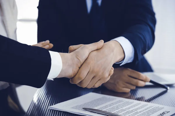 Zakenmensen schudden elkaar de hand na het tekenen van een contract in een modern kantoor. Teamwork, partnerschap en handdruk concept — Stockfoto