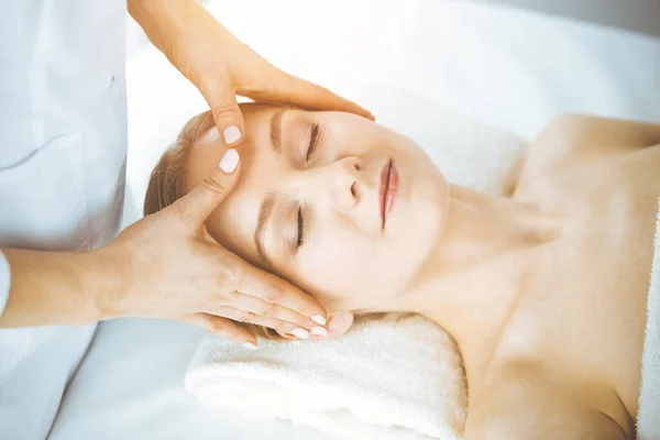 Mutlu kadın spa salonunda kapalı gözlerle yüz masajından zevk alıyor. Tıp ve Güzellik konseptinde rahatlatıcı tedavi — Stok fotoğraf