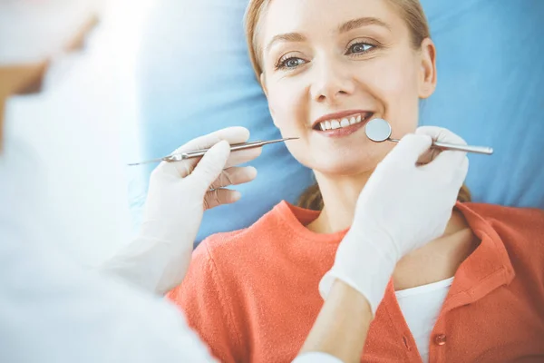 Happy woman is being examined by dentist at dental clinic. Healthy teeth and medicine, stomatology concept — Stock Photo, Image