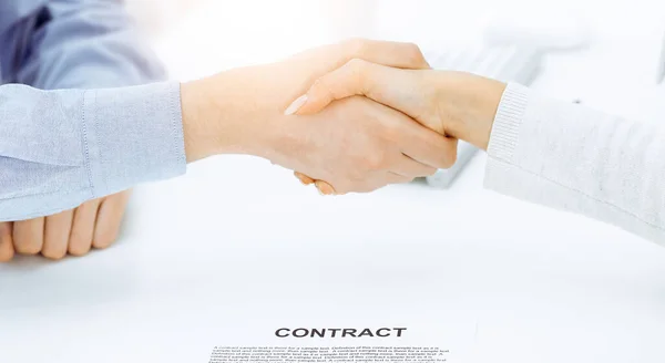 Alkalmi öltözetű üzletember és nő kezet ráznak, miután aláírták a szerződést a napfényes irodában. Kézfogás fogalma — Stock Fotó