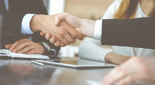 Onbekende zakenmannen schudden handen boven het glazen bureau in een modern kantoor, close-up. Onbekende zakenmensen bij een ontmoeting. Teamwork, partnerschap en handdruk concept — Stockfoto