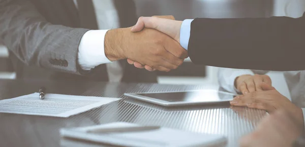 Handshake as successful negotiation ending, close-up. Unknown business people shaking hands after contract signing in modern office