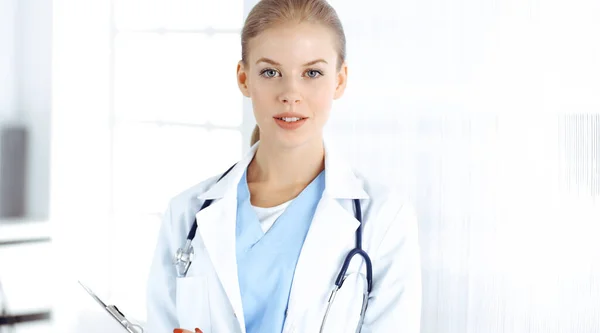Woman - doctor standing in clinic. Physician at work, studio portrait. Medicine and health care concept Stock Photo