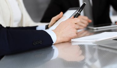 Modern bir ofiste birlikte çalışan iş adamları. Meslektaşları ya da avukatları olan tanınmamış işadamı ve kadın sözleşmeyle ilgili görüşmede