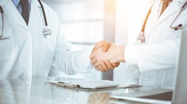 İki doktor hastaların tedavisi konusunda anlaşmak için el sıkışıyor, yakın plan. Tıbbi yardım, tıp konsepti