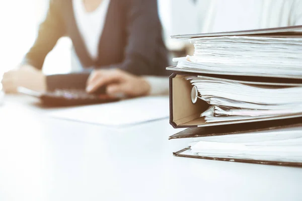 Ordner mit Papieren warten darauf, von Geschäftsfrau oder Buchhalterin am Schreibtisch im Büro verarbeitet zu werden. Wirtschaftsprüfungs- und Steuerkonzept — Stockfoto