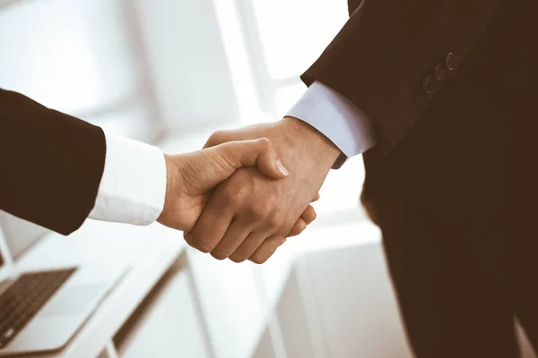 Businessman and woman shaking hands in office. Concept of handshake as success symbol in business — Stock Photo, Image