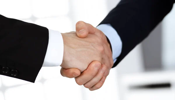 Podnikatelé si potřásají rukama po podpisu smlouvy, když stojí v moderní kanceláři. Koncept týmové práce a potřesení rukou — Stock fotografie