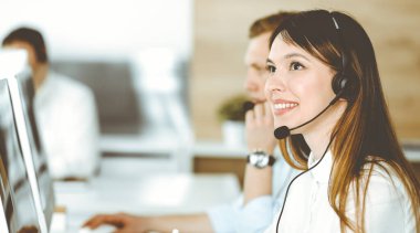 Çağrı merkezinde çalışan çeşitli operatörler. Güzel Asyalı kadın müşteri hizmetleri ofisinde kulaklık takıyor. İş konsepti