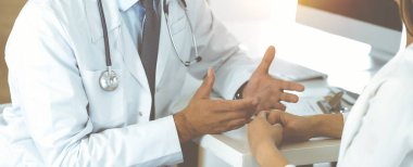 Bilinmeyen doktor ve hasta güneşli klinikteki masada otururken bir şey tartışıyorlar.