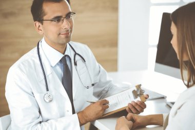 Doktor ve hasta klinikteki masada otururken bir şey tartışıyorlar. Tıp kavramı ve klinikte rahat hizmet