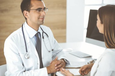 Doktor ve hasta klinikteki masada otururken bir şey tartışıyorlar. Tıp kavramı ve klinikte rahat hizmet