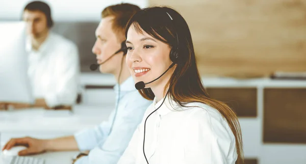呼叫中心的一组不同的操作员在工作.美丽的亚洲女人坐在客户服务办公室的耳机里。业务概念 — 图库照片