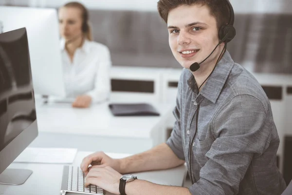 Centro de llamadas. Grupo de operadores vestidos casuales en el trabajo. Empresario con auriculares en la oficina de servicio al cliente. Telesales en el negocio —  Fotos de Stock