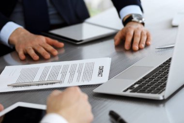 İş adamları modern ofiste birlikte çalışarak sözleşmeyi tartışıyor. Meslektaşları veya avukatları olan tanınmamış işadamı ve kadın görüşmede