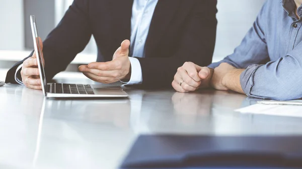 Gente de negocios que usa computadora portátil mientras trabajan juntos en el escritorio en la oficina moderna. Empresario desconocido o empresario masculino con colega en el lugar de trabajo. Trabajo en equipo y concepto de asociación — Foto de Stock