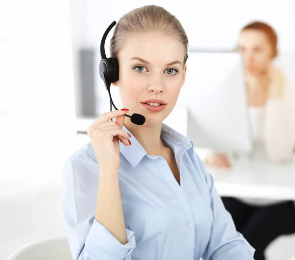 Mujer rubia trabajando en un centro de llamadas soleado. Grupo de personas diversas que trabajan como ocupación de servicio al cliente. Concepto empresarial — Foto de Stock