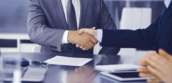 Onbekende zakenmensen schudden elkaar de hand na het tekenen van een contract in een modern kantoor, close-up. Handdruk als succesvol onderhandelingsresultaat — Stockfoto