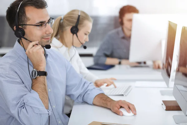 Call center. Group of casual dressed operators at work. Adult businessman in headset at customer service office. Telesales in business — Stock Photo, Image