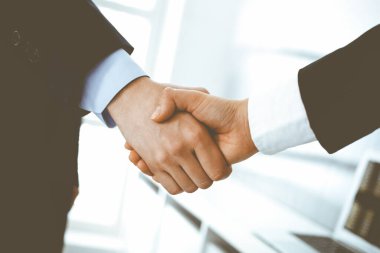 İş adamı ve kadın ofiste el sıkışıyor. İş hayatında başarı sembolü olarak el sıkışma kavramı