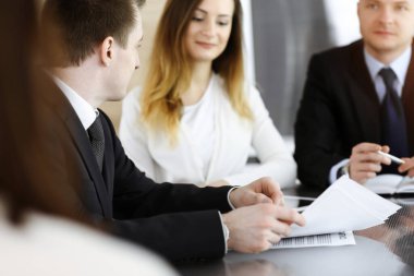 İş adamları ya da avukatlar güneşli ofiste soruları tartışıyorlar. Bilinmeyen iş adamı ve iş arkadaşı cam masada oturuyor ve çalışıyor.