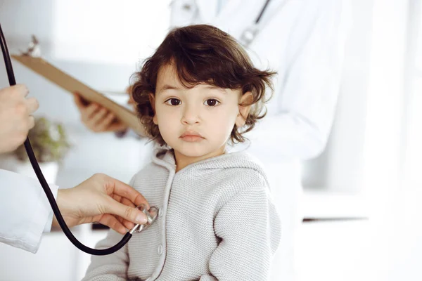 Vrouwendokter die een kindpatiënt onderzoekt met stethoscoop. Leuke Arabische peuter op afspraak bij de dokter. Geneesmiddelenconcept — Stockfoto