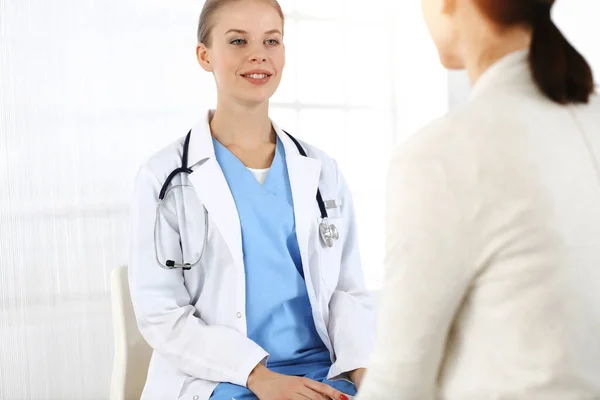 Mujer: el médico consulta a su paciente femenino en una clínica soleada — Foto de Stock