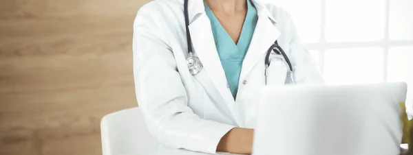 Ismeretlen női orvos ül és laptopot használ a klinikán, közelről. Orvosi fogalom — Stock Fotó