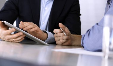 Modern ofiste birlikte çalışırken iş adamları tablet bilgisayar kullanıyorlar. İş yerinde iş arkadaşı olan tanınmamış bir iş adamı ya da erkek girişimci. Takım çalışması ve ortaklık kavramı