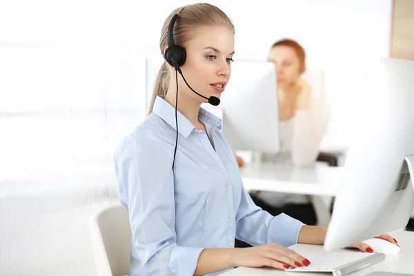 Mujer rubia trabajando en un centro de llamadas soleado. Grupo de personas diversas que trabajan como ocupación de servicio al cliente. Concepto empresarial — Foto de Stock